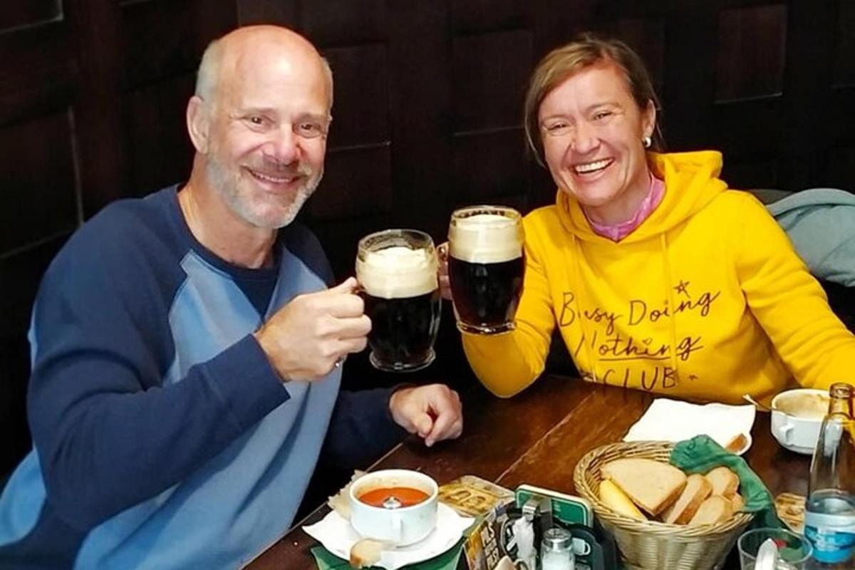 a man and woman sitting at a table drinking beer