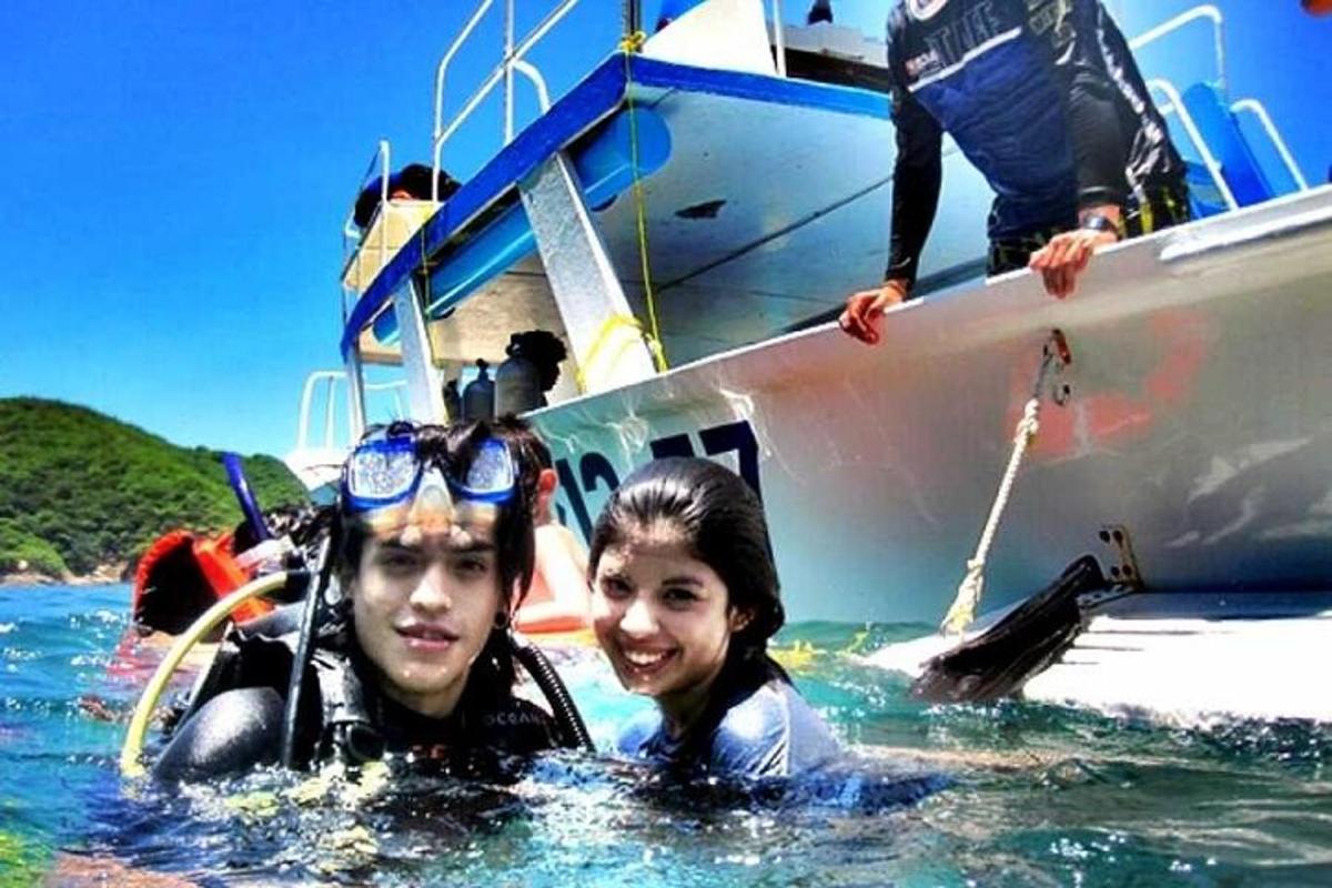 two people in the water in front of a boat