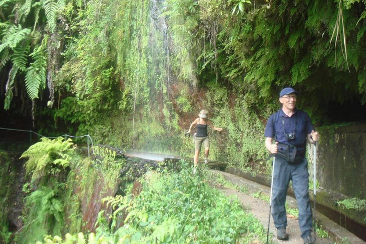 seorang lelaki dan seorang wanita berdiri di hadapan air terjun