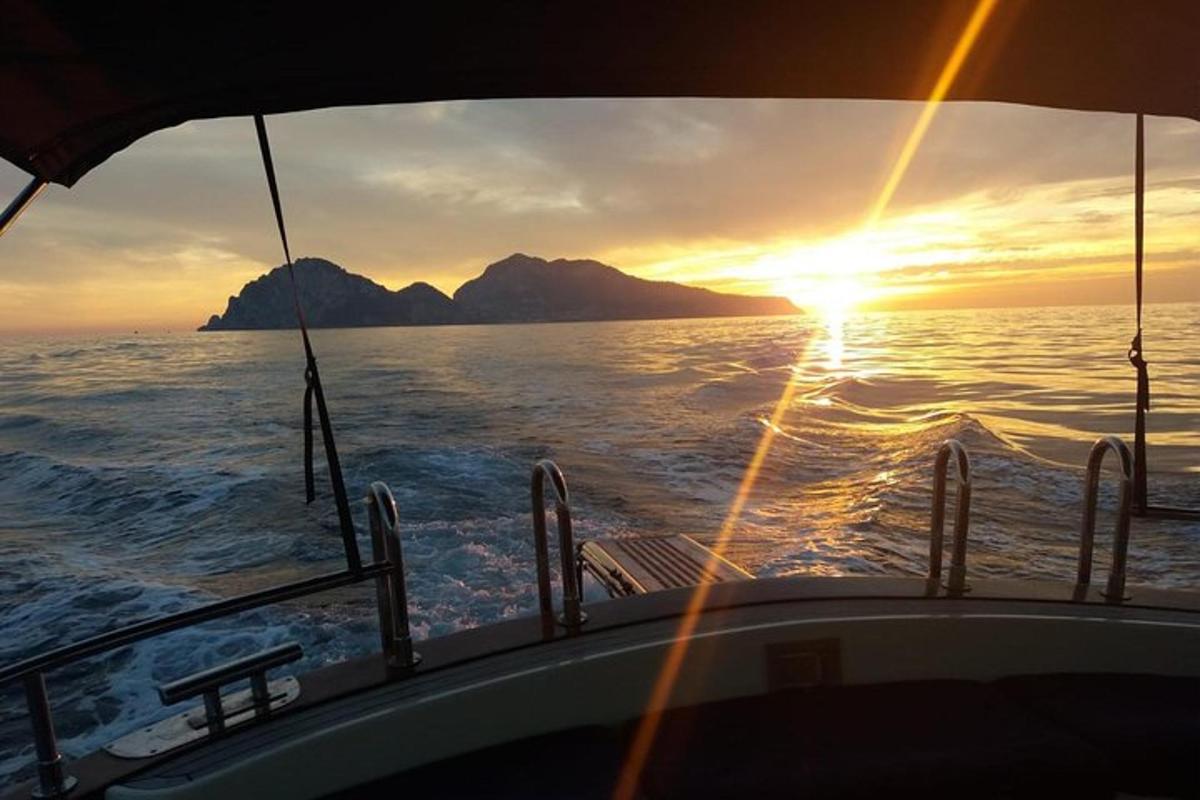 um barco no oceano com o pôr do sol