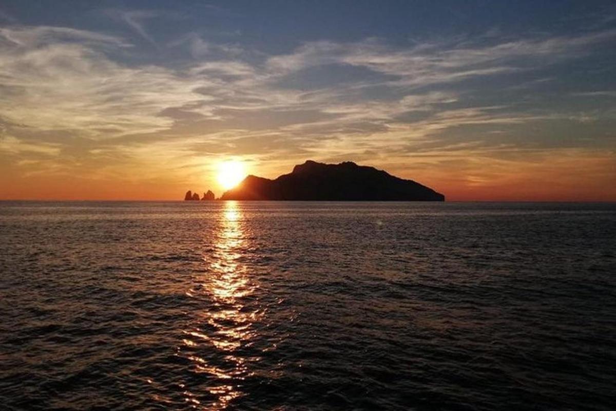 una posta de sol sobre una gran massa d'aigua