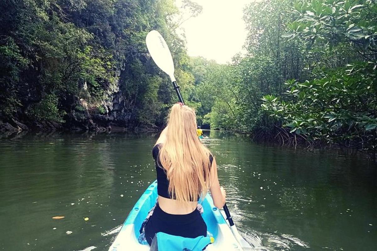 una donna sta pagaiando su un kayak su un fiume
