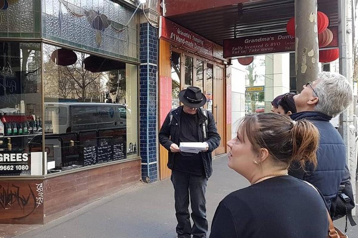 a man standing outside of a store looking at his cell phone
