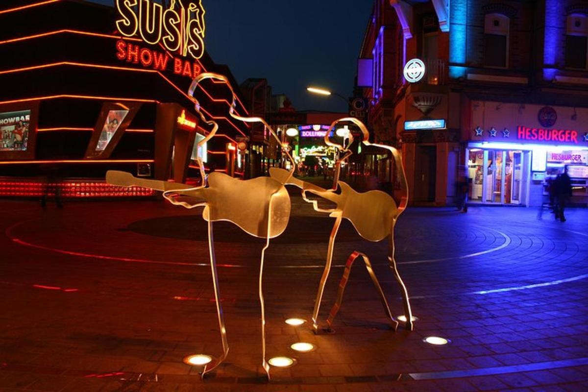 algumas estátuas de girafas em uma rua à noite