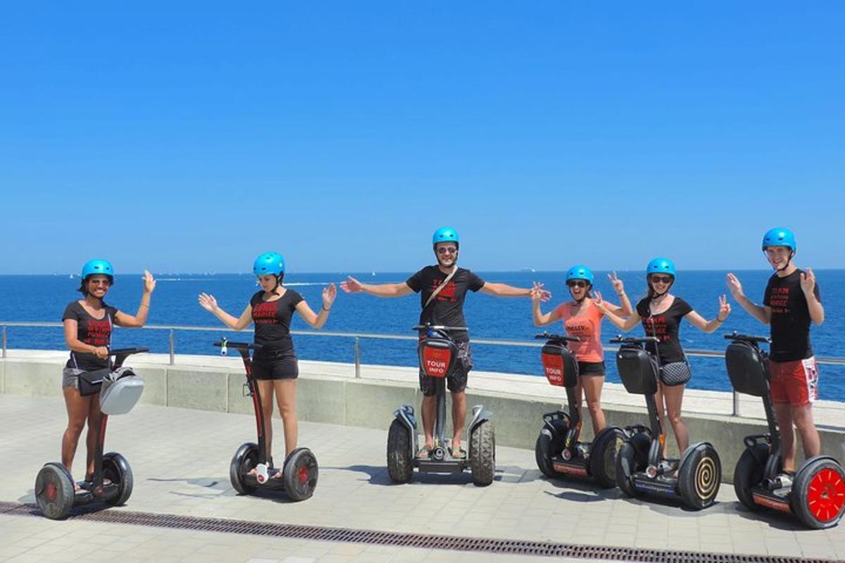 Skupina lidí jezdících na segwayích na pláži
