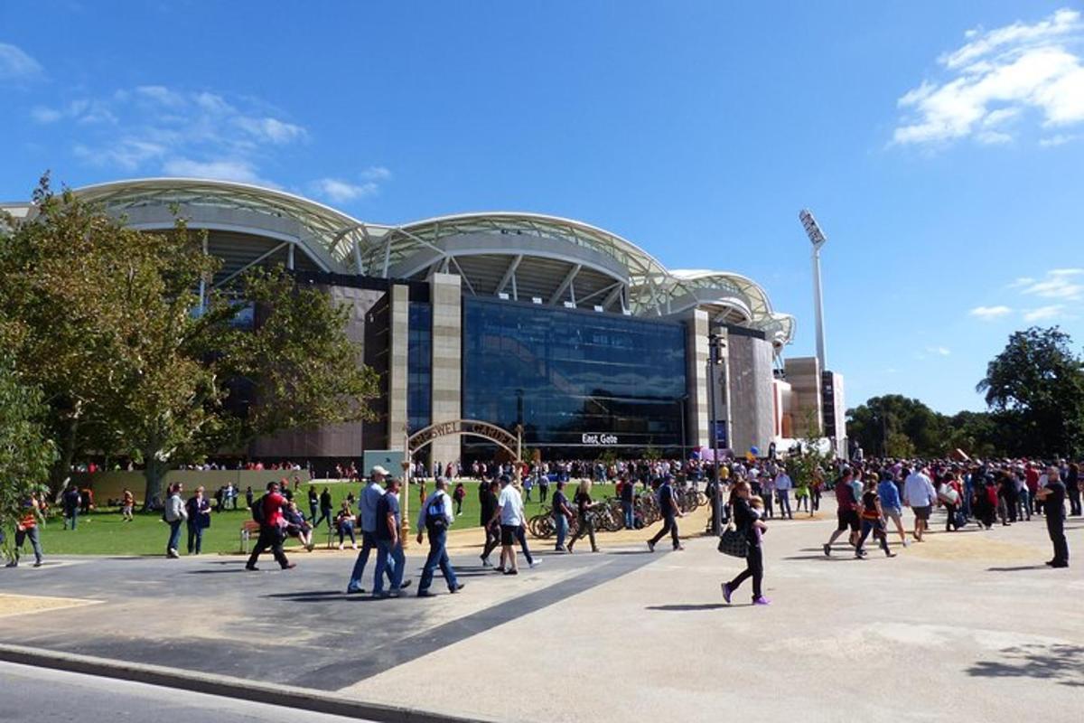 un folto gruppo di persone che camminano davanti a uno stadio