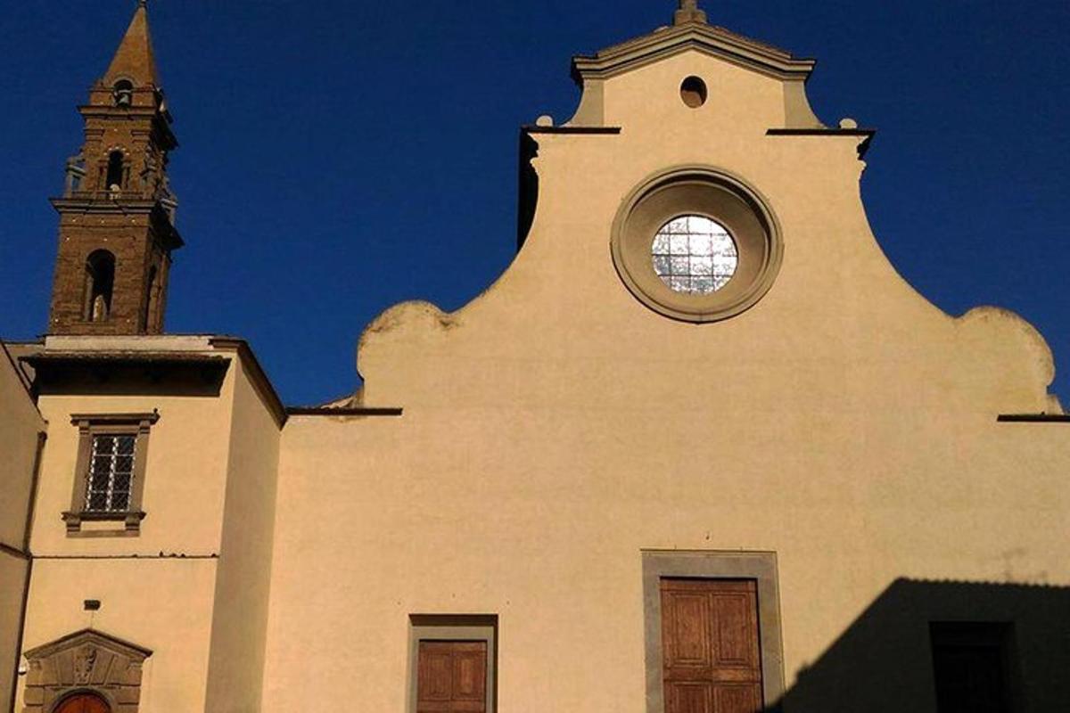 een witte kerk met een klokkentoren en een raam