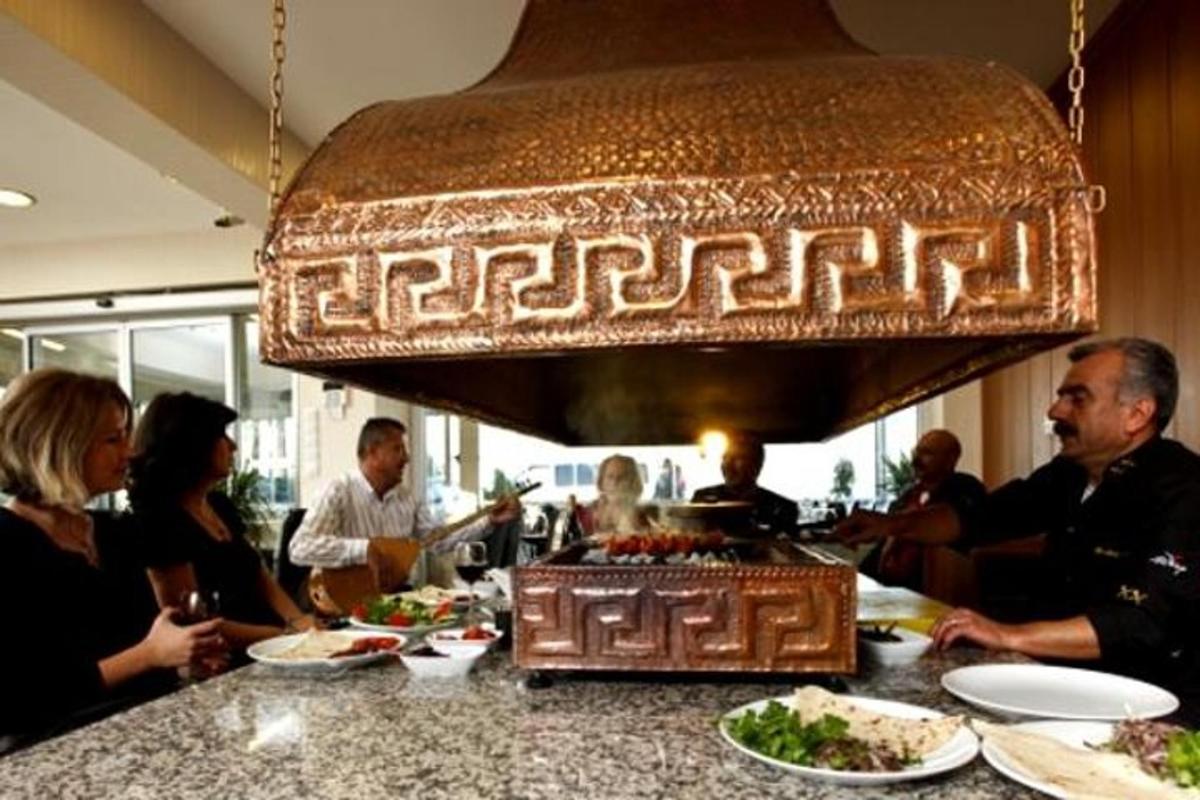 a group of people sitting at a table with food