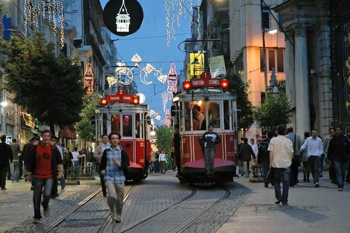 two trolley cars on a busy city street with people