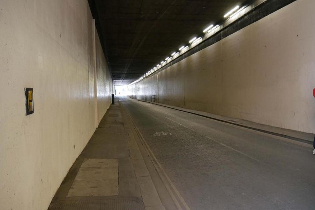 um túnel vazio com uma pessoa caminhando por ele