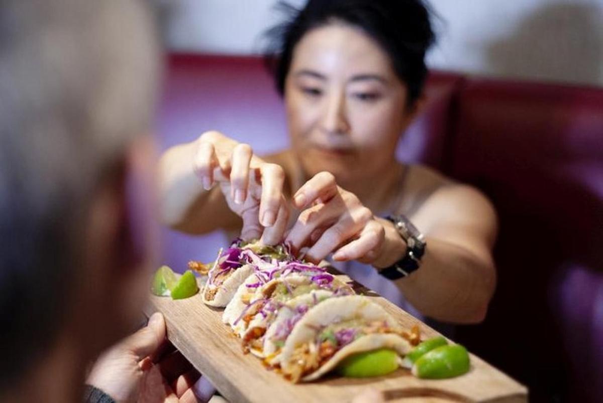 a woman is holding a plate of food