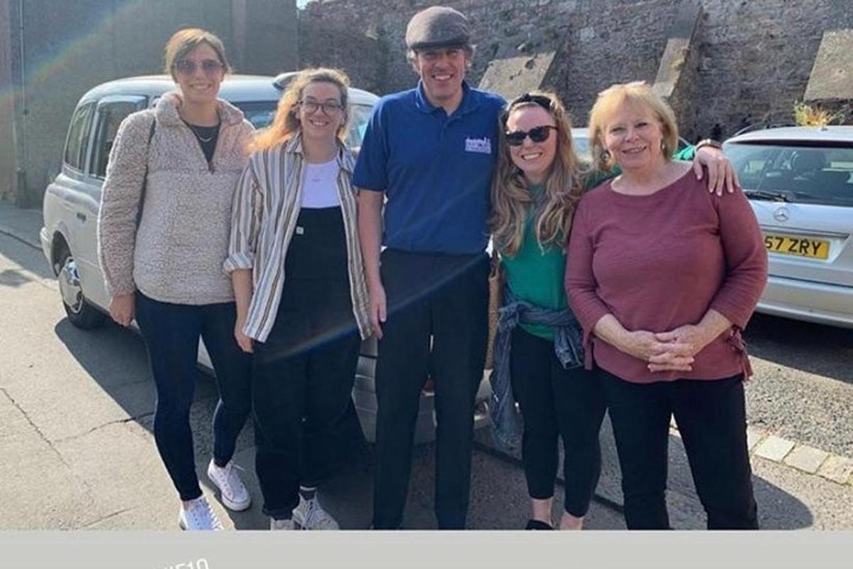 a group of people standing in front of a car