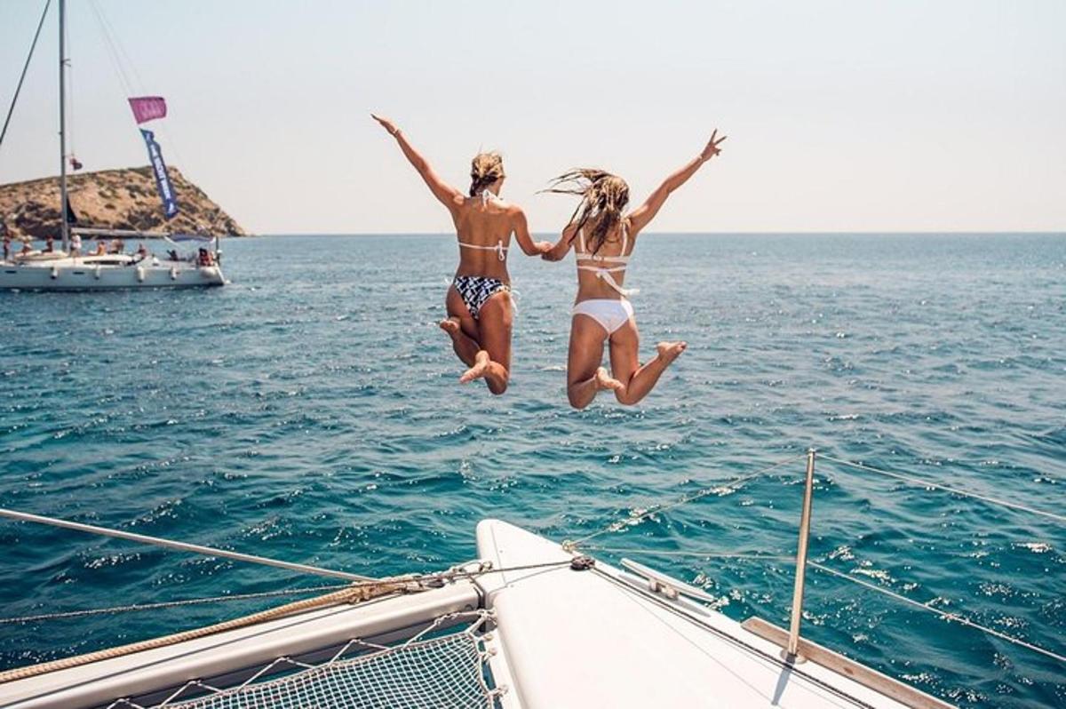 two girls jumping off of a boat in the water