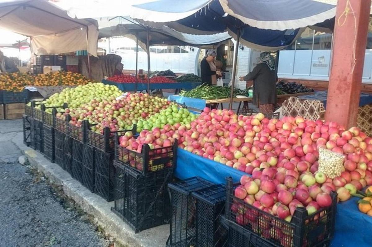 un mercato con molti cesti di mele e altri frutti