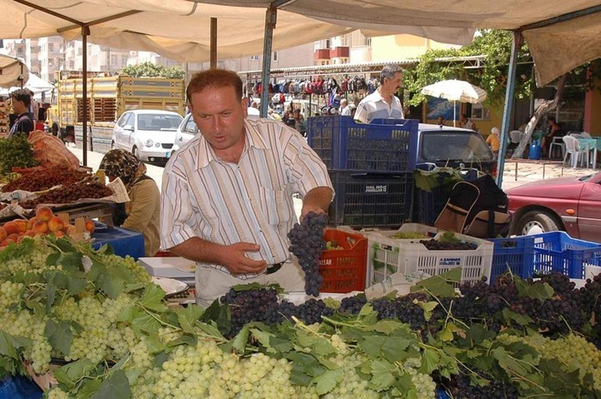un uomo che prepara l'uva in un mercato agricolo all'aperto