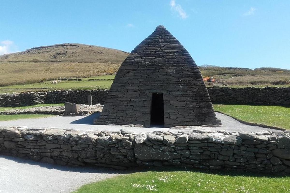 steinveggur með litlu húsi á túni
