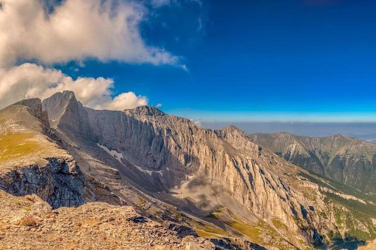 útsýni yfir fjall með bláum himni og skýjum