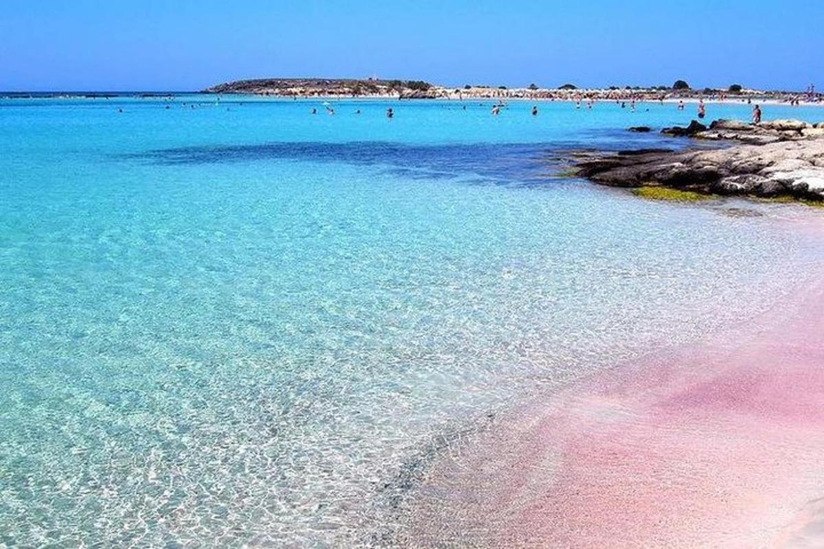 μια παραλία με μια ομάδα ανθρώπων στο νερό