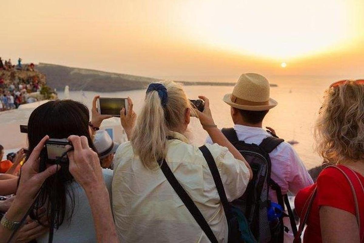 un gruppo di persone che scattano foto del tramonto