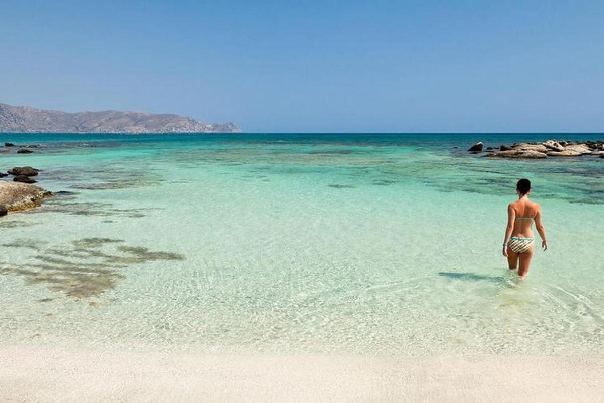 μια γυναίκα που περπατάει στο νερό σε μια παραλία