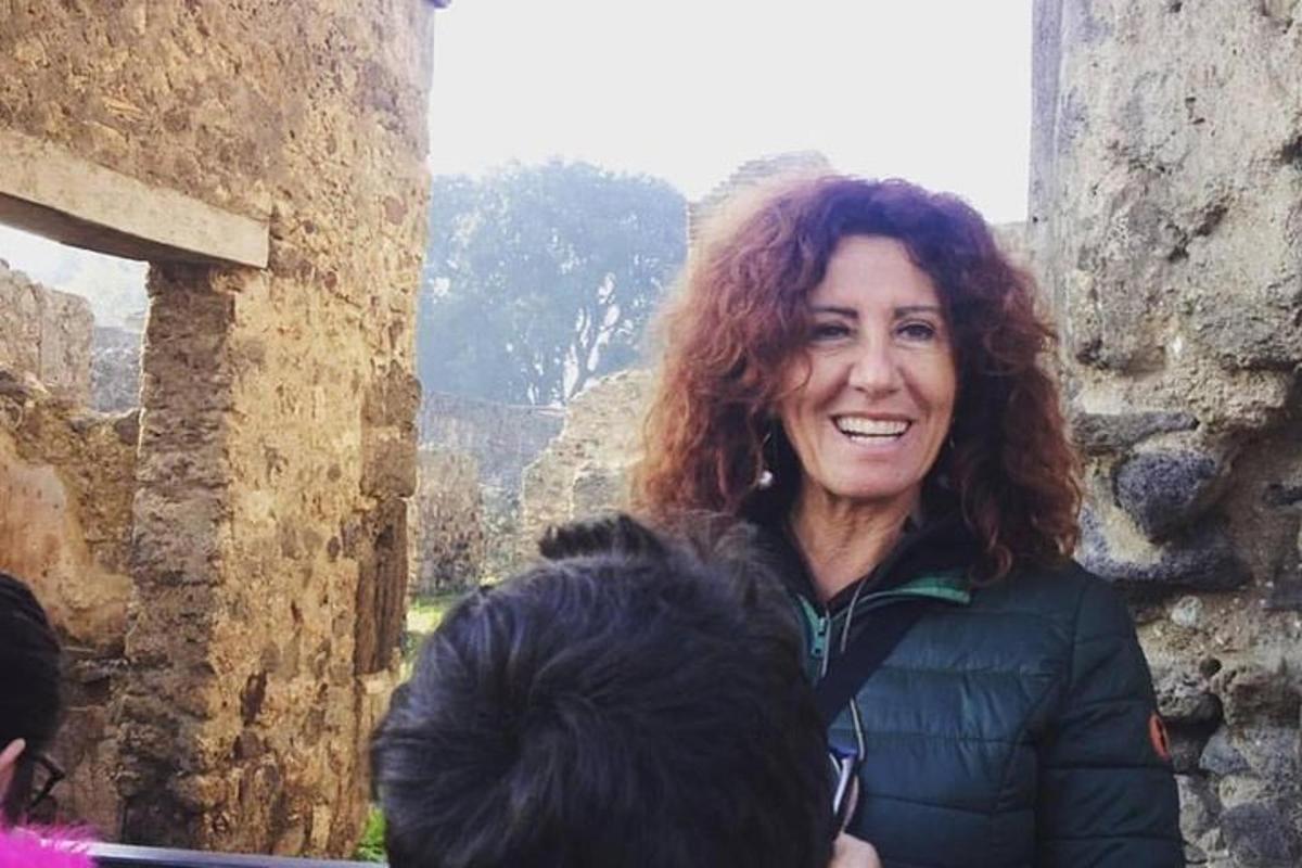 una dona somriu mentre està dreta en un edifici