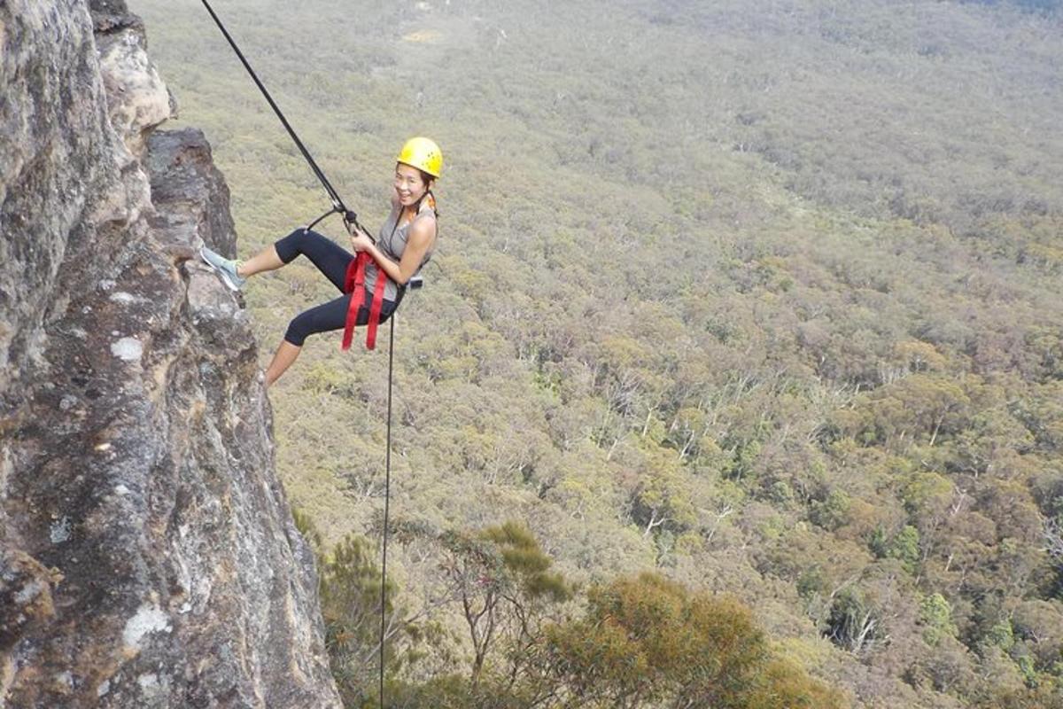 a woman on a zip line hanging from a cliff