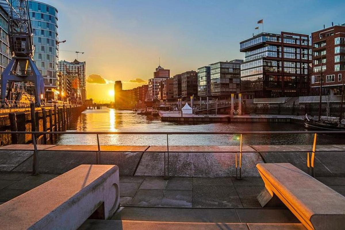 un tramonto su una città con due panchine e un fiume