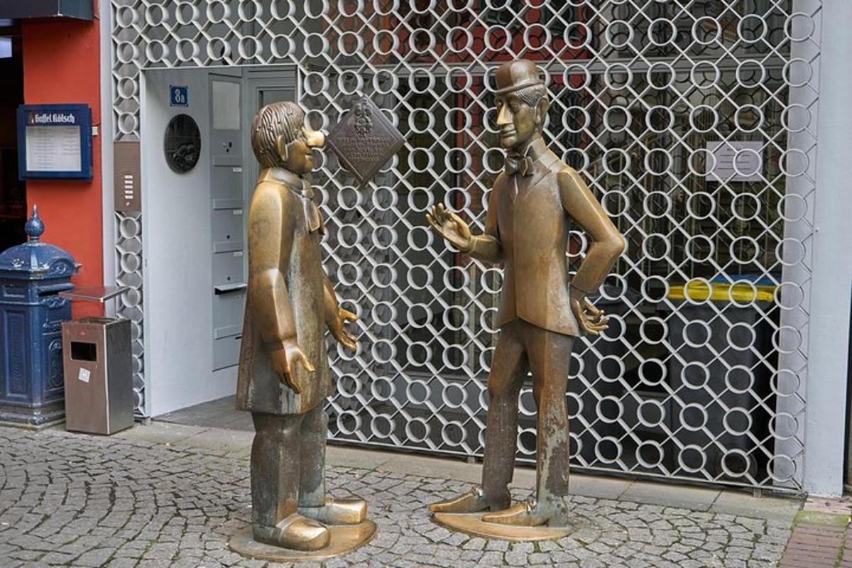 two bronze statues of men standing in front of a building