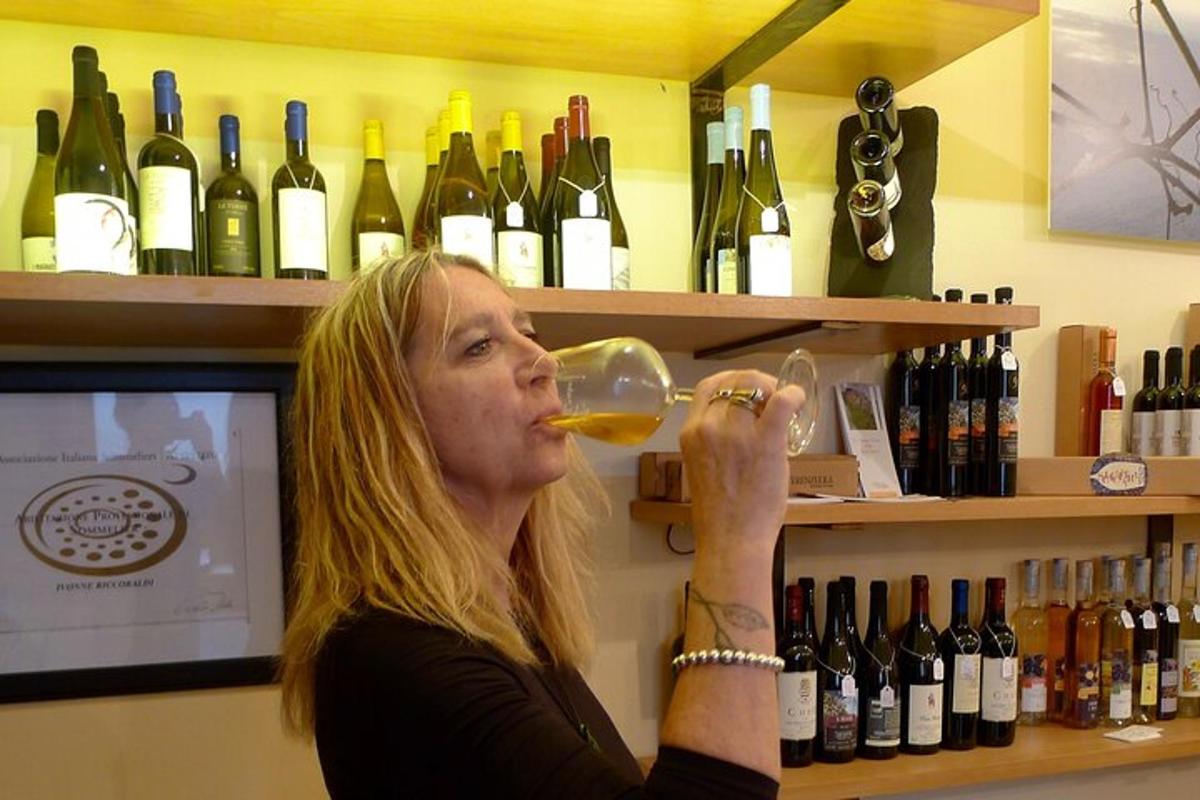 a woman drinking a glass of wine in a wine store