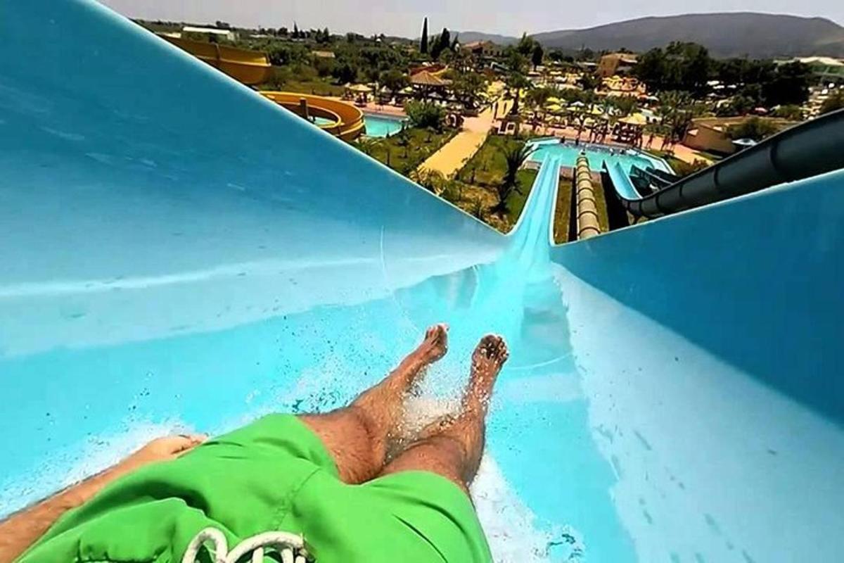a person on a water slide in a swimming pool