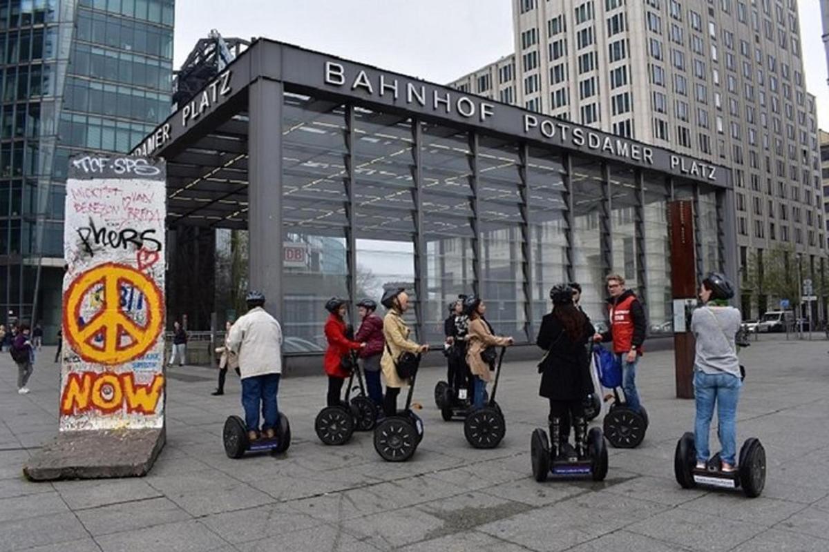 en gruppe mennesker som kjører på segwayer foran en bygning