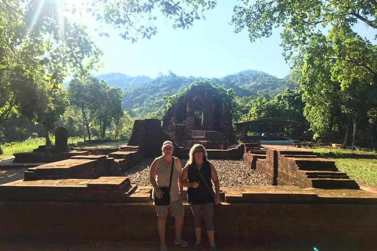 Dos mujeres están paradas frente a una ruina.
