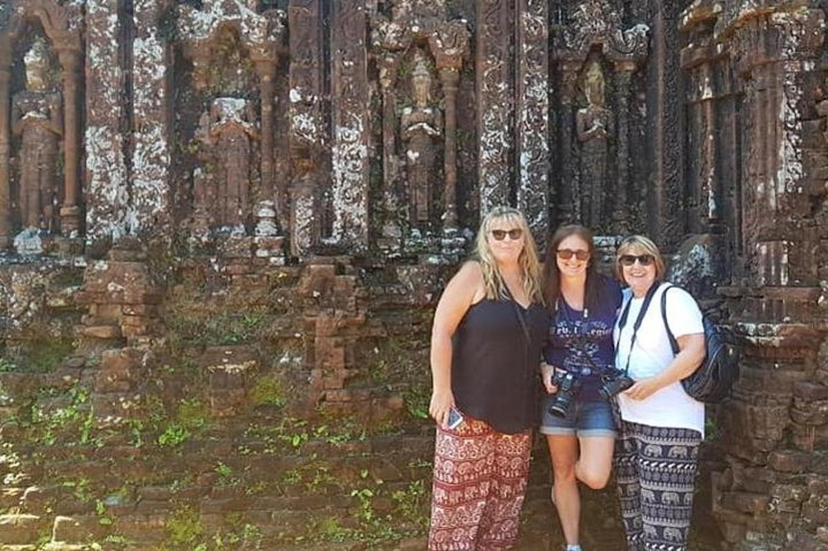 tiga orang wanita berdiri di hadapan sebuah bangunan