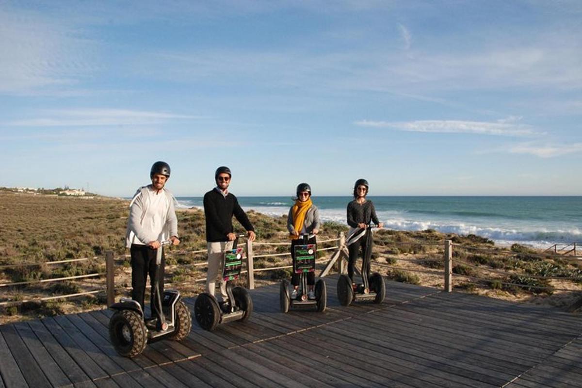 Skupina lidí jezdících na segwayích na pláži