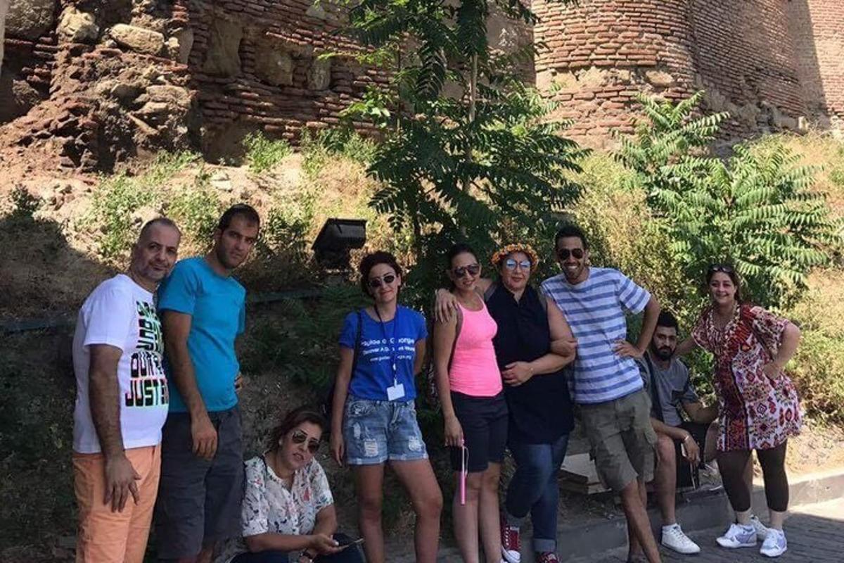 un grup de oameni care pozează pentru o fotografie în fața unui castel