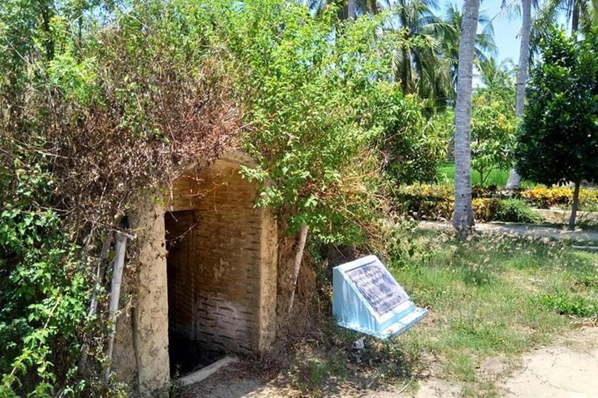 a brick structure with a sign in the grass