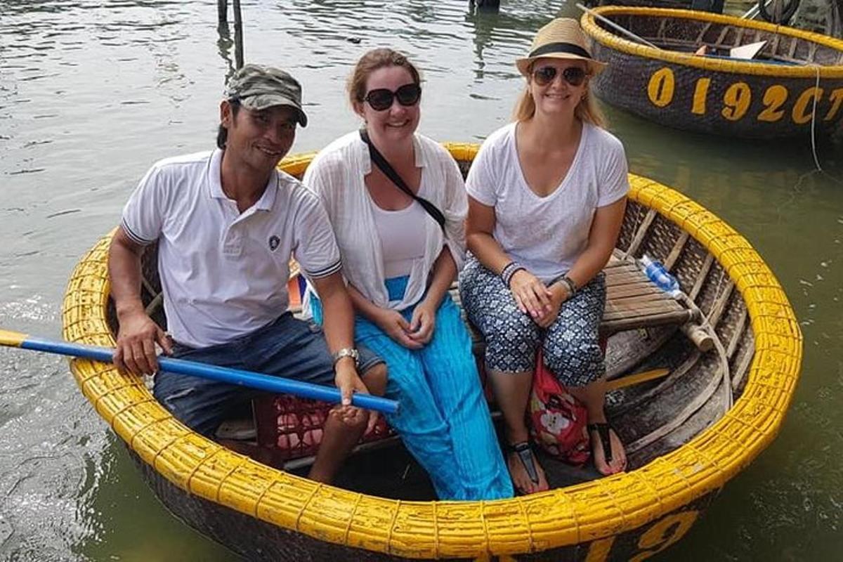 tre persone sedute su una barca gialla sull'acqua