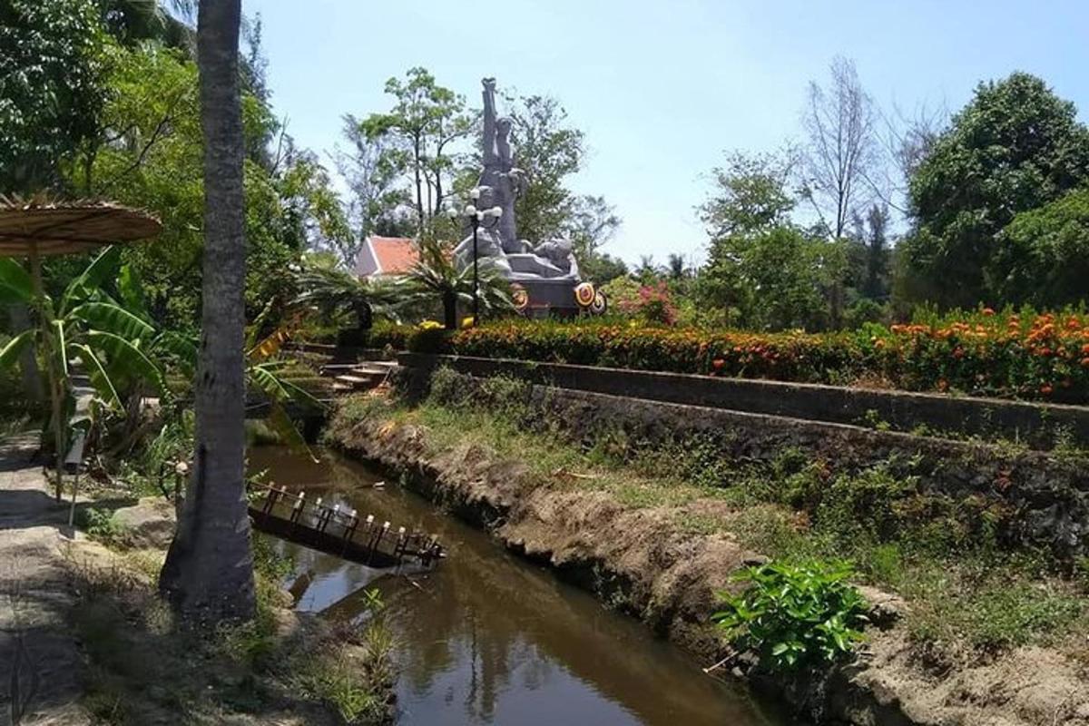 a river in a garden with a statue in the background