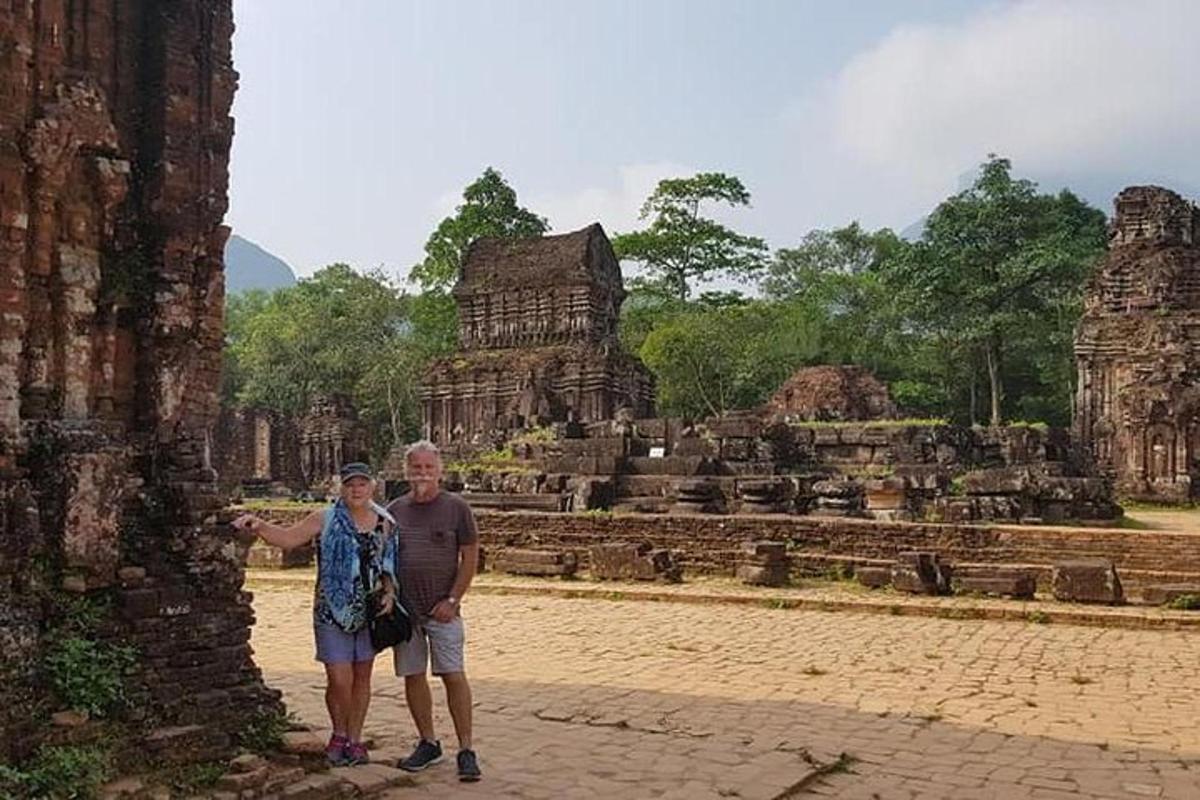 a man and a woman standing in front of a temple