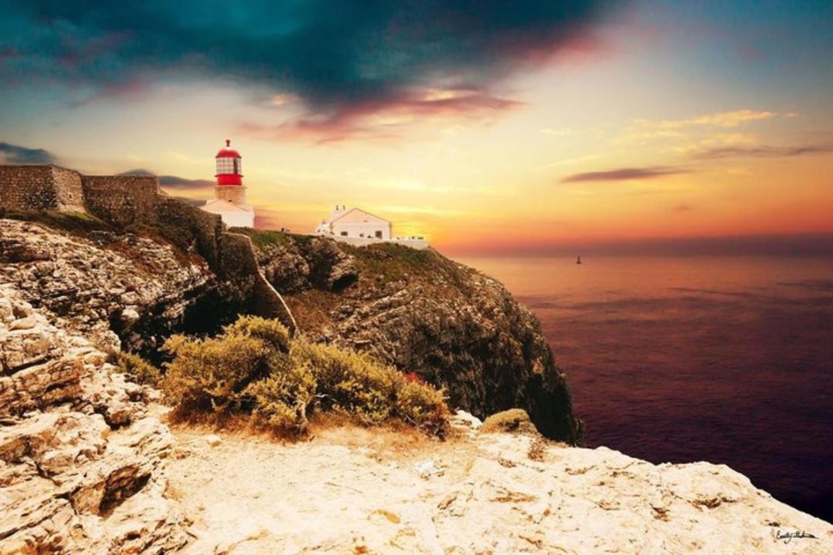 a lighthouse sitting on top of a cliff next to the ocean