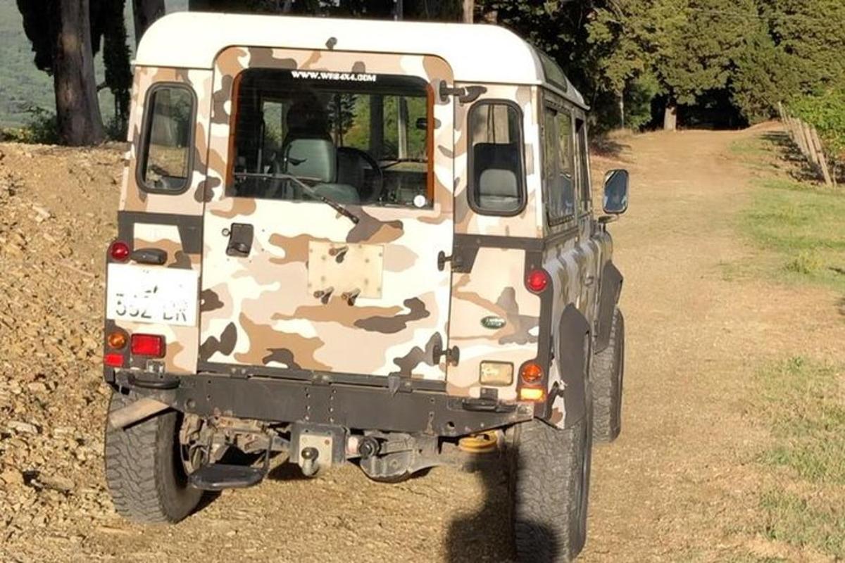 um caminhão camuflado estacionado em uma estrada de terra