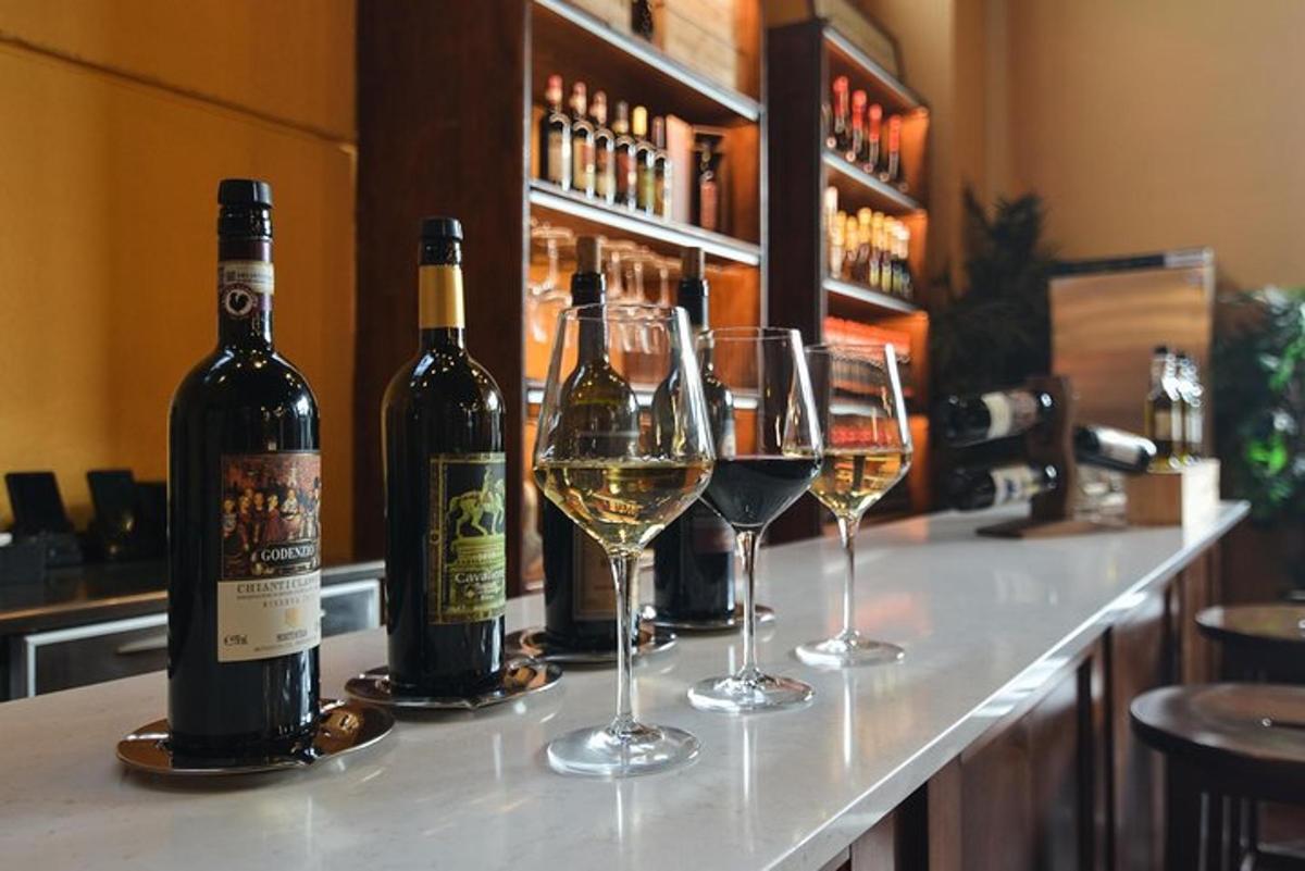 tre bottiglie di vino e bicchieri di vino su un bar