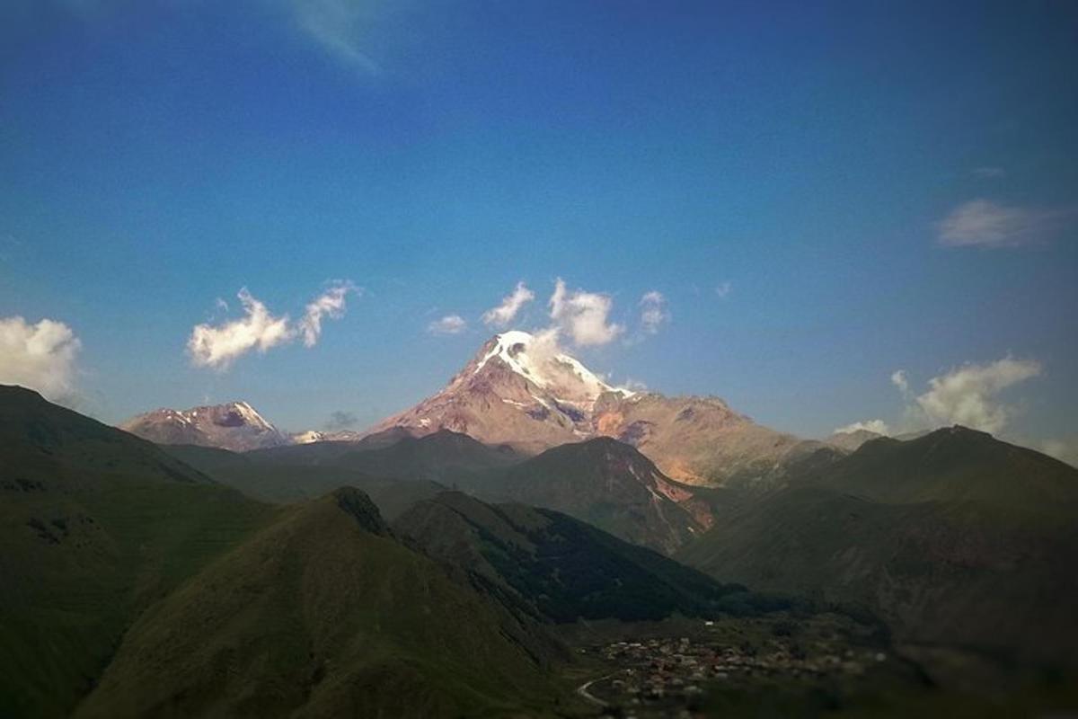 un munte acoperit de zăpadă cu un oraș în fața lui