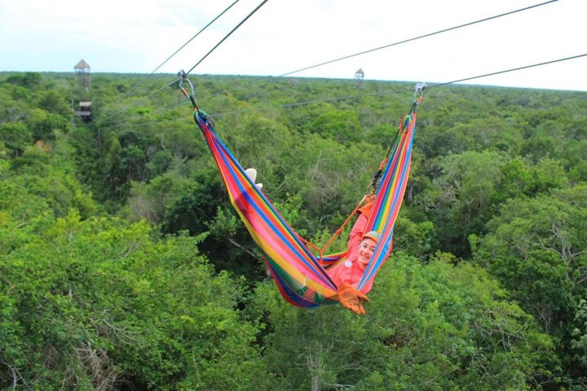 a person in a hammock hanging from a wire