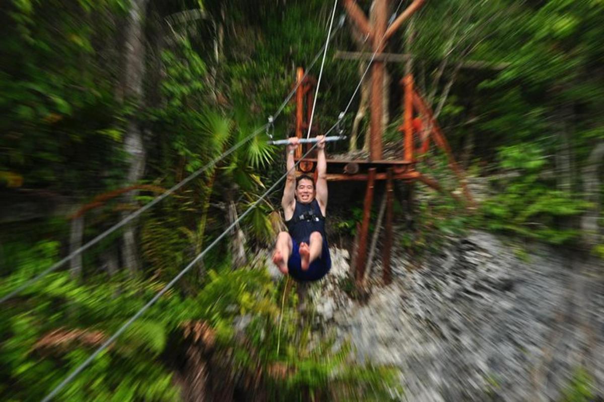 Ein Mann hängt an einer Seilrutsche im Wald