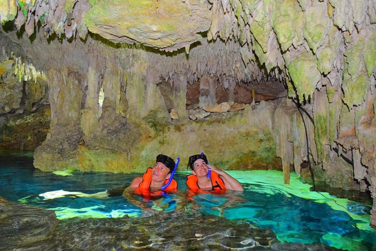 zwei Menschen schwimmen in einem Wasserbecken in einer Höhle