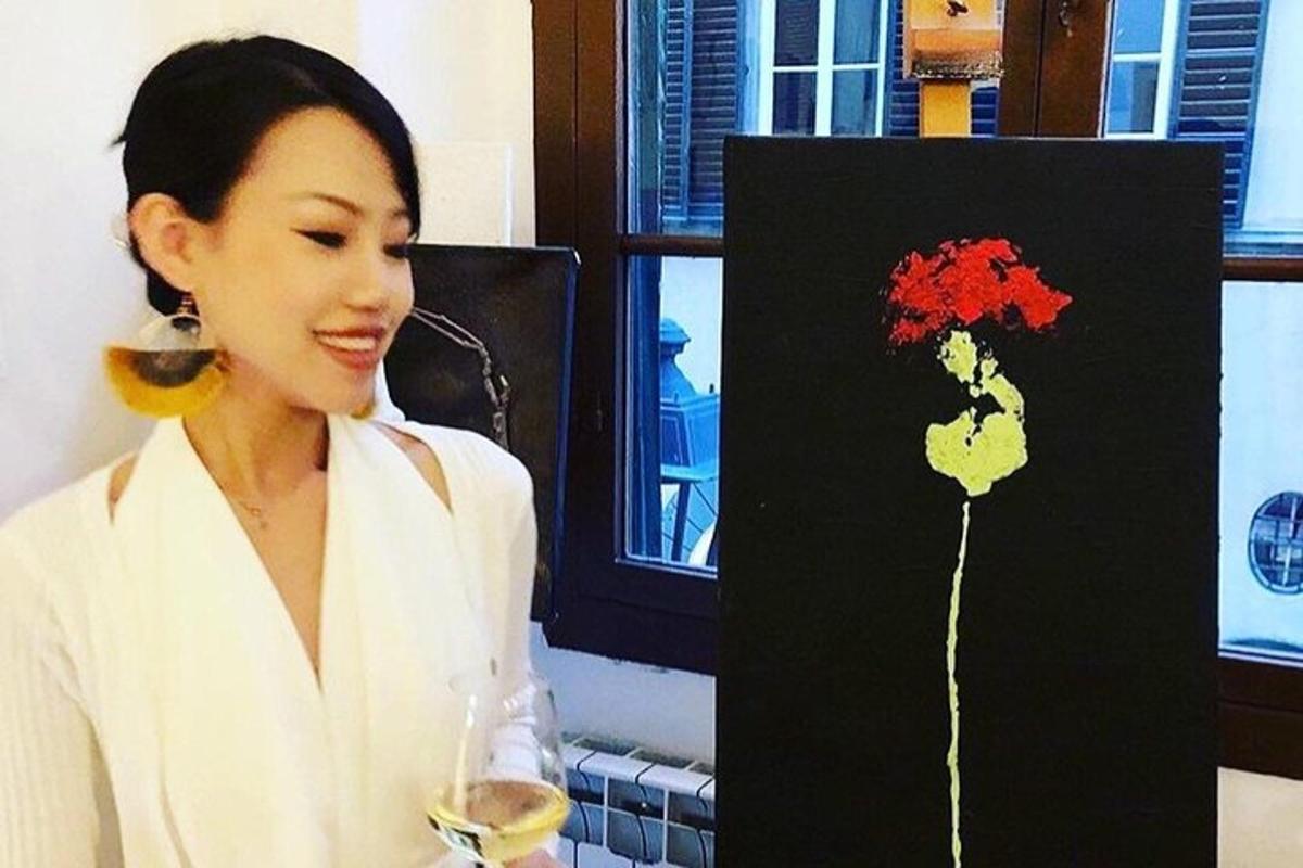 와인 한 잔과 꽃 그림을 들고 있는 여자