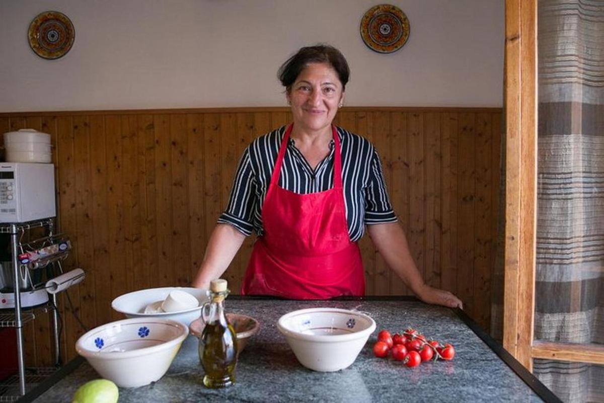 žena v červenej zástere stojaca za pultom