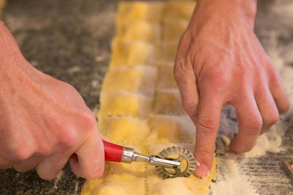seseorang menggunakan pemotong kue untuk memotong sepotong makanan