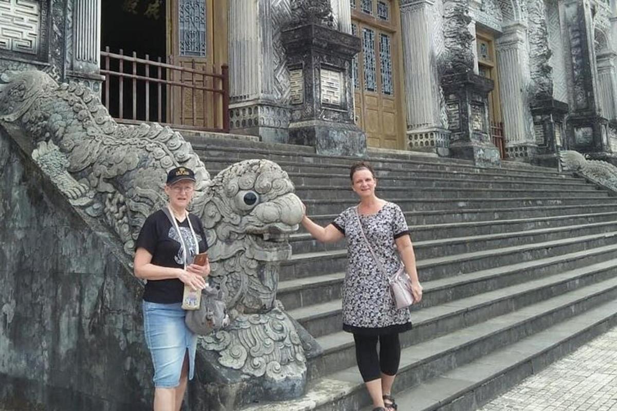dvě ženy stojící vedle sochy před budovou